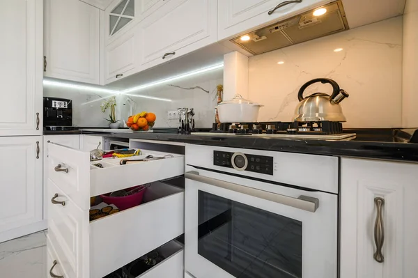 Πολυτελές λευκό μοντέρνα κουζίνα εσωτερικό, συρτάρια τράβηξε έξω, πλυντήρια πιάτων πόρτα ανοιχτή — Φωτογραφία Αρχείου