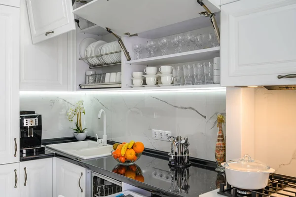 Luxuoso branco moderno cozinha interior, gavetas puxadas para fora, portas abertas — Fotografia de Stock