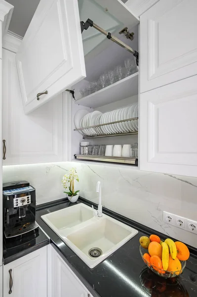 Luxuoso branco moderno cozinha interior, gavetas puxadas para fora, portas abertas — Fotografia de Stock