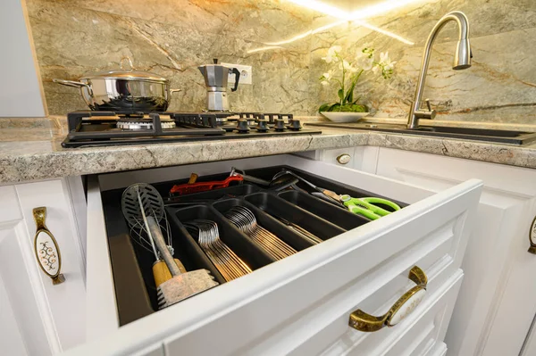 Drawers pulled out at modern classic white kitchen furniture