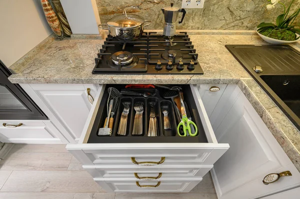 Drawers pulled out at modern classic white kitchen furniture