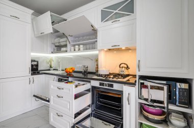 Lüks beyaz modern mutfak, çekmeceler kapalı, fırın kapısı açık.