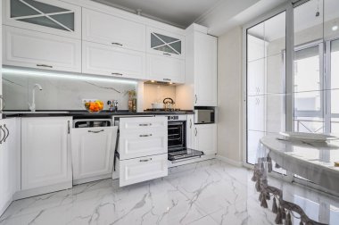 Lüks beyaz modern mutfak, çekmeceler kapalı, bulaşık makinelerinin kapısı açık.