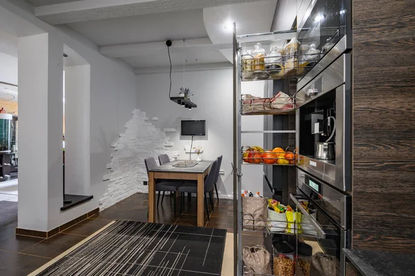 Moderne luxe grote bruine keuken met eettafel en verticale lade uitgeschoven — Stockfoto