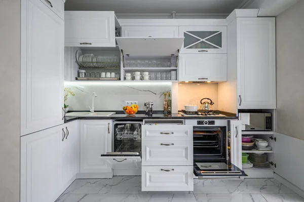 Luksusowe białe, nowoczesne wnętrze kuchni, wysuwane szuflady, otwarte drzwi zmywarki — Zdjęcie stockowe
