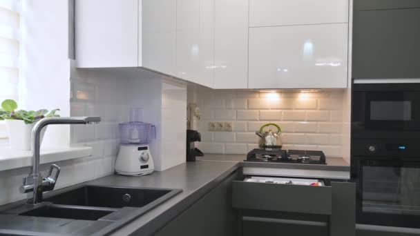 Closeup panorama of modern white and grey kitchen interior with rack focus — Stock Video