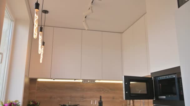 Brett vinkel lutning skott av modernt vitt och trä beige kök interiör — Stockvideo