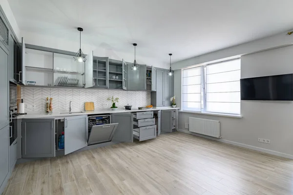 Trendy grey and white modern kitchen furniture with doors open — Stock Photo, Image