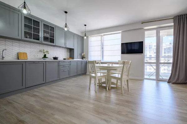 Modne szaro-białe nowoczesne meble kuchenne w studio apartamencie — Zdjęcie stockowe