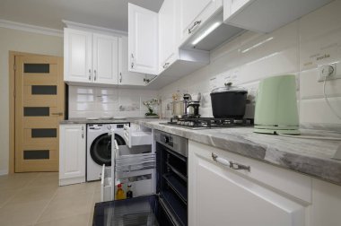 Lüks beyaz, kapısı açık modern mutfak mobilyaları.
