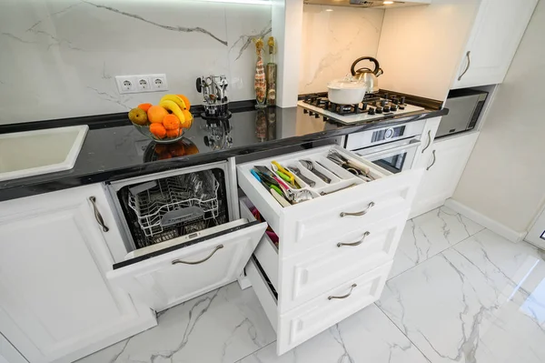 Luxusní bílý moderní kuchyňský interiér, vytažené zásuvky, dveře od myček, vysoký úhel — Stock fotografie