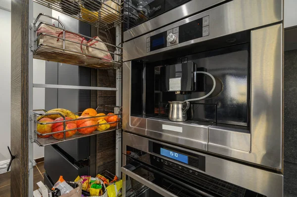 Moderne luxe grote bruine keuken met eettafel en verticale lade uitgeschoven — Stockfoto
