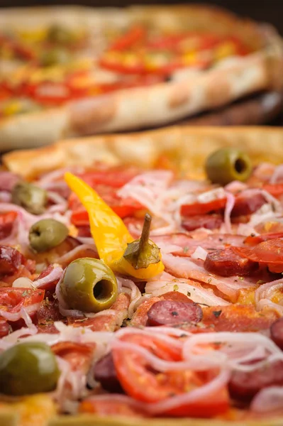 Pizza con tomate, salami, peppeeoni, aceitunas y pimiento picante amarillo — Foto de Stock
