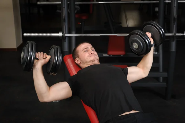 Jongeman doet Bench Press Workout in Gym Rechtenvrije Stockfoto's