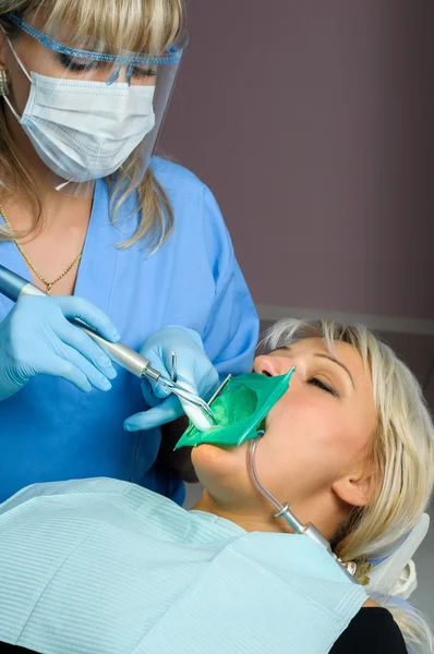 Dentist with patient, using dental curing light — Stock Photo, Image