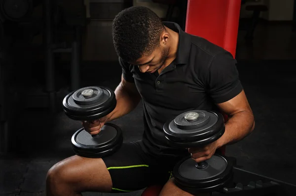 Young man sitting on bench at gym — Stock Photo, Image