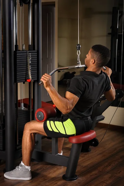 Young man doing lats pull-down workout — Stock Photo, Image