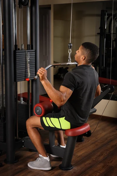 Young man doing lats pull-down workout — Stock Photo, Image