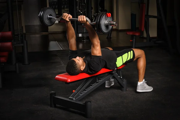 Young man doing arms bench french press workout in gym — Stock Photo, Image