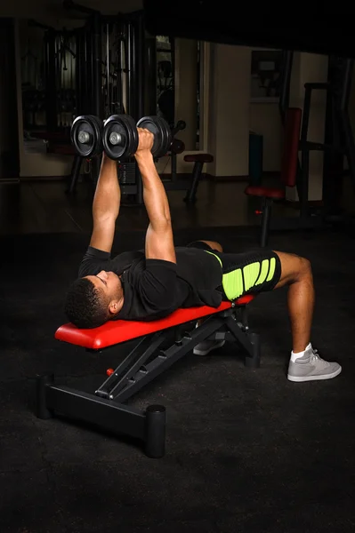 Ung man göra vapen bänk flyger träning i gym — Stockfoto