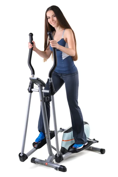 Young woman doing exercises on elliptical trainer — Stock Photo, Image