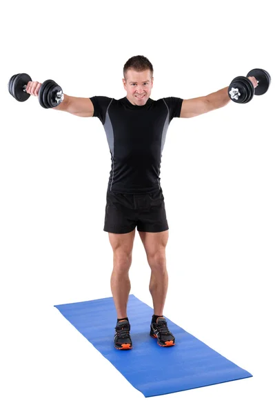 Ung man visar slutposition av hantel lateral raise — Stockfoto