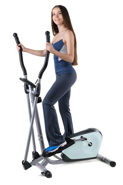 Young woman doing exercises on elliptical trainer — Stock Photo, Image