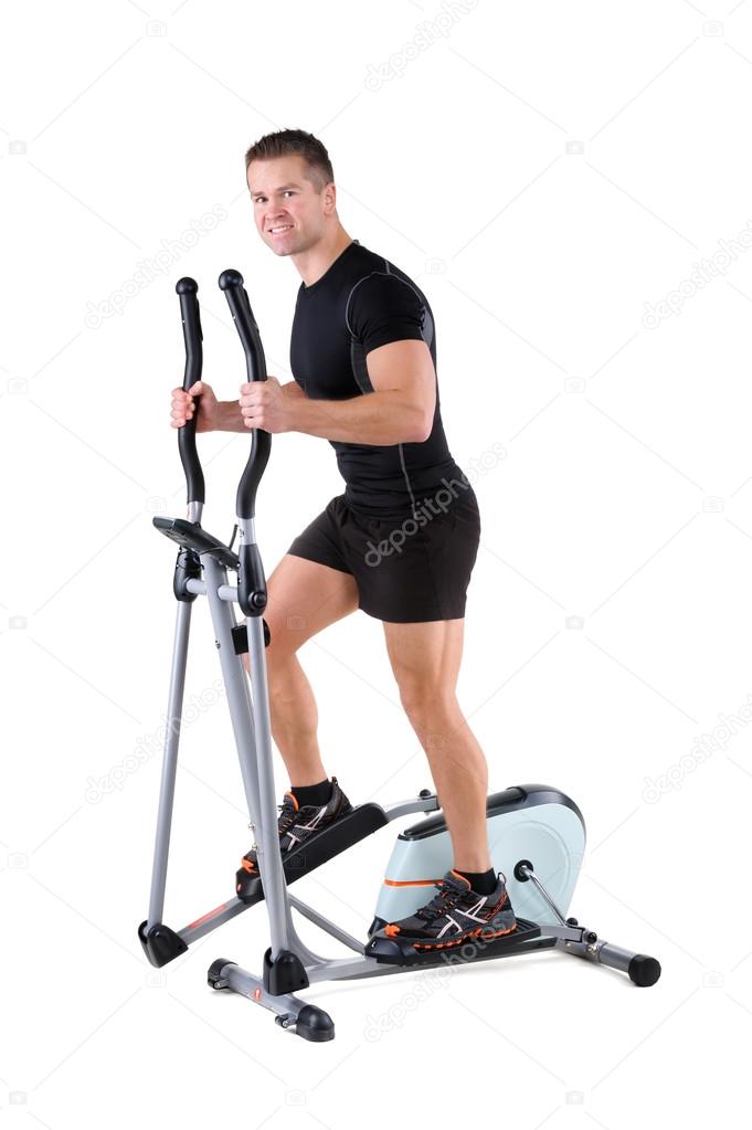 Young man doing exercises on elliptical trainer Stock Photo starush 89289466