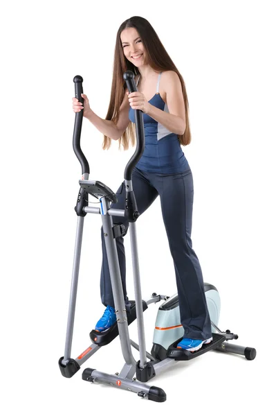 Young woman doing exercises on elliptical trainer — Stock Photo, Image