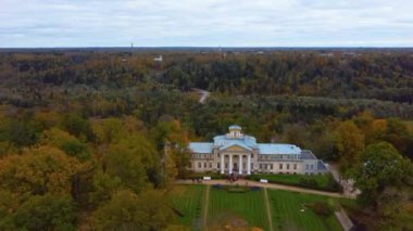 Sigulda ve Turaida, Letonya yakınlarındaki Gauja Ulusal Parkı 'ndaki Krimulda Sarayı' nın hava görüntüsü. Sonbaharda Bahçeli Eski Malikane. Gauja Nehri 'nin Eski Vadisi, Krimulda, Krimulda Malikânesi, Turaida Şatosu' nun olduğu Dağ 'daki Renkli Orman. 4K Video