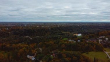 Sigulda ve Turaida, Letonya yakınlarındaki Gauja Ulusal Parkı 'ndaki Krimulda Sarayı' nın hava görüntüsü. Sonbaharda Bahçeli Eski Malikane. Gauja Nehri 'nin Eski Vadisi, Krimulda, Krimulda Malikânesi, Turaida Şatosu' nun olduğu Dağ 'daki Renkli Orman. 4K Video