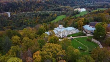 Sigulda ve Turaida, Letonya yakınlarındaki Gauja Ulusal Parkı 'ndaki Krimulda Sarayı' nın hava görüntüsü. Sonbaharda Bahçeli Eski Malikane. Gauja Nehri 'nin Eski Vadisi, Krimulda, Krimulda Malikânesi, Turaida Şatosu' nun olduğu Dağ 'daki Renkli Orman. 4K Video