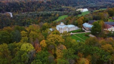 Sigulda ve Turaida, Letonya yakınlarındaki Gauja Ulusal Parkı 'ndaki Krimulda Sarayı' nın hava görüntüsü. Sonbaharda Bahçeli Eski Malikane. Gauja Nehri 'nin Eski Vadisi, Krimulda, Krimulda Malikânesi, Turaida Şatosu' nun olduğu Dağ 'daki Renkli Orman. 4K Video