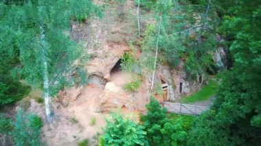  Ligatne, Letonya 'daki Kum Taşı Mağaraları. Ligatne Nehri kıyısındaki Mağara Rock Lustuzis 'e bakın. Eski Ahşap Kapılı Mağaralar.