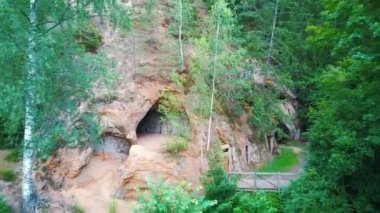  Ligatne, Letonya 'daki Kum Taşı Mağaraları. Ligatne Nehri kıyısındaki Mağara Rock Lustuzis 'e bakın. Eski Ahşap Kapılı Mağaralar.