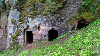Ligatne Town 'daki Anfabrika Kayalıkları ve Mahzenleri Eski Baraj Barajı. Letonya 'daki Gauja Ulusal Parkı' ndaki Antik Kum Taşı Mağaraları ve Antik Odaları