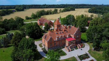 Jaunmoku Brick Ortaçağ Şatosu, Tukums yakınlarında, Letonya Açık Güneşli Yaz Günü 'nde Parfümlü Havuz' da, Top View 'dan. Jaunmokas Malikânesi Parkı. Hava Dron 4k Atışı