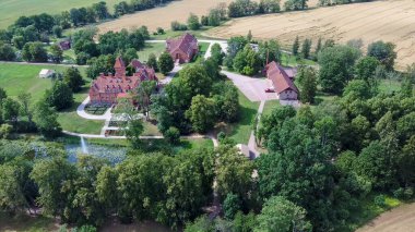 Jaunmoku Brick Ortaçağ Şatosu, Tukums yakınlarında, Letonya Açık Güneşli Yaz Günü 'nde Parfümlü Havuz' da, Top View 'dan. Jaunmokas Malikânesi Parkı. Hava Dron 4k Atışı