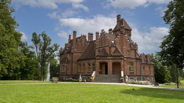 Tume, Letonya 7 Temmuz 2020, Tuğla Ortaçağ Jaunmoku Kalesi. Jaunmokas Malikânesi Parkı. Bu Neo-gotik Saray 1901 'de Mimar Wilhelm Bockslaff tarafından tasarlandı..