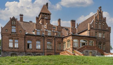 Tume, Letonya 7 Temmuz 2020, Tuğla Ortaçağ Jaunmoku Kalesi. Jaunmokas Malikânesi Parkı. Bu Neo-gotik Saray 1901 'de Mimar Wilhelm Bockslaff tarafından tasarlandı..