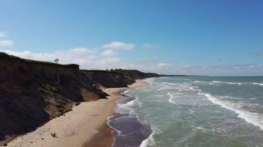 Kıyı şeridi üzerinde uçan Baltık Denizi Uçurumları Pavilosta, Letonya ve Landslides yakınlarındaki Uçan Uçan Mağara, Cliff ve Çakıl Taşlarını noktaladı. Aerial Dron Manzarası. Kamera 4K Videosunu İleri Taşır