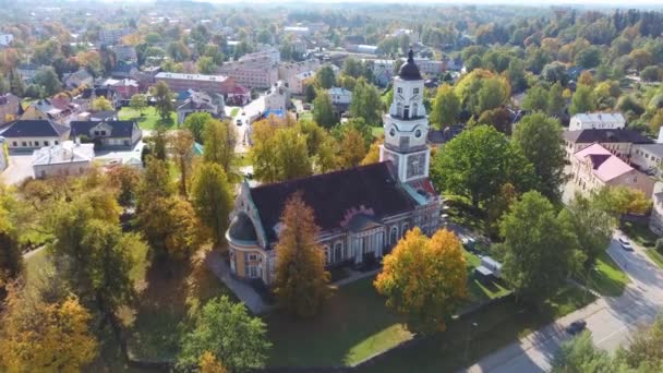 Alte lutherische Kirche in Aluksne im farbenfrohen Herbstpark mit einer Statue des goldenen Hahns auf der Turmspitze. Aluksne City Lettland. Drohnenschuss aus der Luft