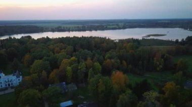 Stameriena, Letonya 'daki Stameriena Gölü yakınlarındaki Eski Saray' ın havadan görüntüsü. Sunset 'te Renkli Sonbahar Manzarası Zamanı. İskender Nevsky Ortodoks Kilisesi ve Doğu Letonya 'daki Stameriena Şatosu. 4k Video
