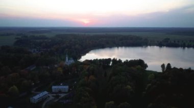 Stameriena, Letonya 'daki Stameriena Gölü yakınlarındaki Eski Saray' ın havadan görüntüsü. Sunset 'te Renkli Sonbahar Manzarası Zamanı. İskender Nevsky Ortodoks Kilisesi ve Doğu Letonya 'daki Stameriena Şatosu. 4k Video