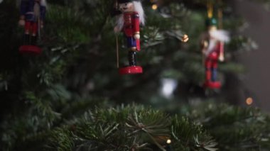 Noel Ağacı 'nda oyuncak fındıkkıran süslemesi. 4K Dolly Kaypak Vuruşu. Bulanık bir geçmişi olan, Noel ağacındaki fındıkkıran asker. Güzel dekore edilmiş Noel Ağacı, Fındıkkıran Oyuncağı, Peri Işıkları.