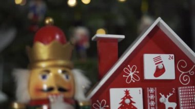 Gerçek Noel Ağacı Önündeki Ahşap Ağaç Gelişmiş Takvim Fındıkkıran Asker Oyuncakları. Bulanık bir geçmişi olan Noel ağacındaki peri ışıkları. Dolly Kaypak 4K şutu. Odaklanmayı Düzenle