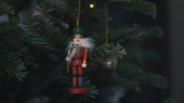 Noel Ağacı 'nda oyuncak fındıkkıran süslemesi. 4K Dolly Kaypak Vuruşu. Bulanık bir geçmişi olan, Noel ağacındaki fındıkkıran asker. Güzel dekore edilmiş Noel Ağacı, Fındıkkıran Oyuncağı, Peri Işıkları.