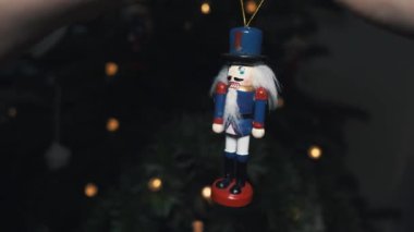 Noel Ağacı 'nda oyuncak fındıkkıran süslemesi. 4K Dolly Kaypak Vuruşu. Bulanık bir geçmişi olan, Noel ağacındaki fındıkkıran asker. Güzel dekore edilmiş Noel Ağacı, Fındıkkıran Oyuncağı, Peri Işıkları.