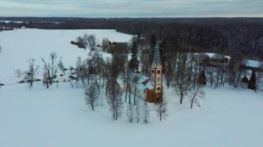 Gündoğumunda Krimulda Evanjelik Lüteryen Kilisesi 'nin hava manzarası. Kubesele Doğa Yolu Krimulda, Letonya 4k Video