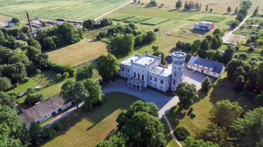 Letonya 'daki Vecauce Malikanesi Pembe Kale' nin Pembe Kale 'ye bakan görüntüsü. Dalgalı Letonya Bayrağı olan Vecauce Kalesi Kulesi. Yukarıdan Görüntüle.
